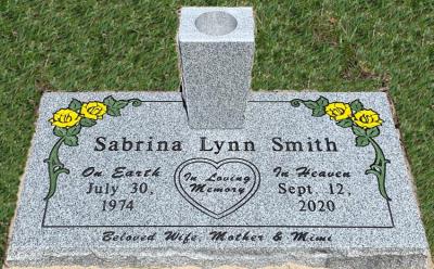 individual gray granite headstone with yellow roses